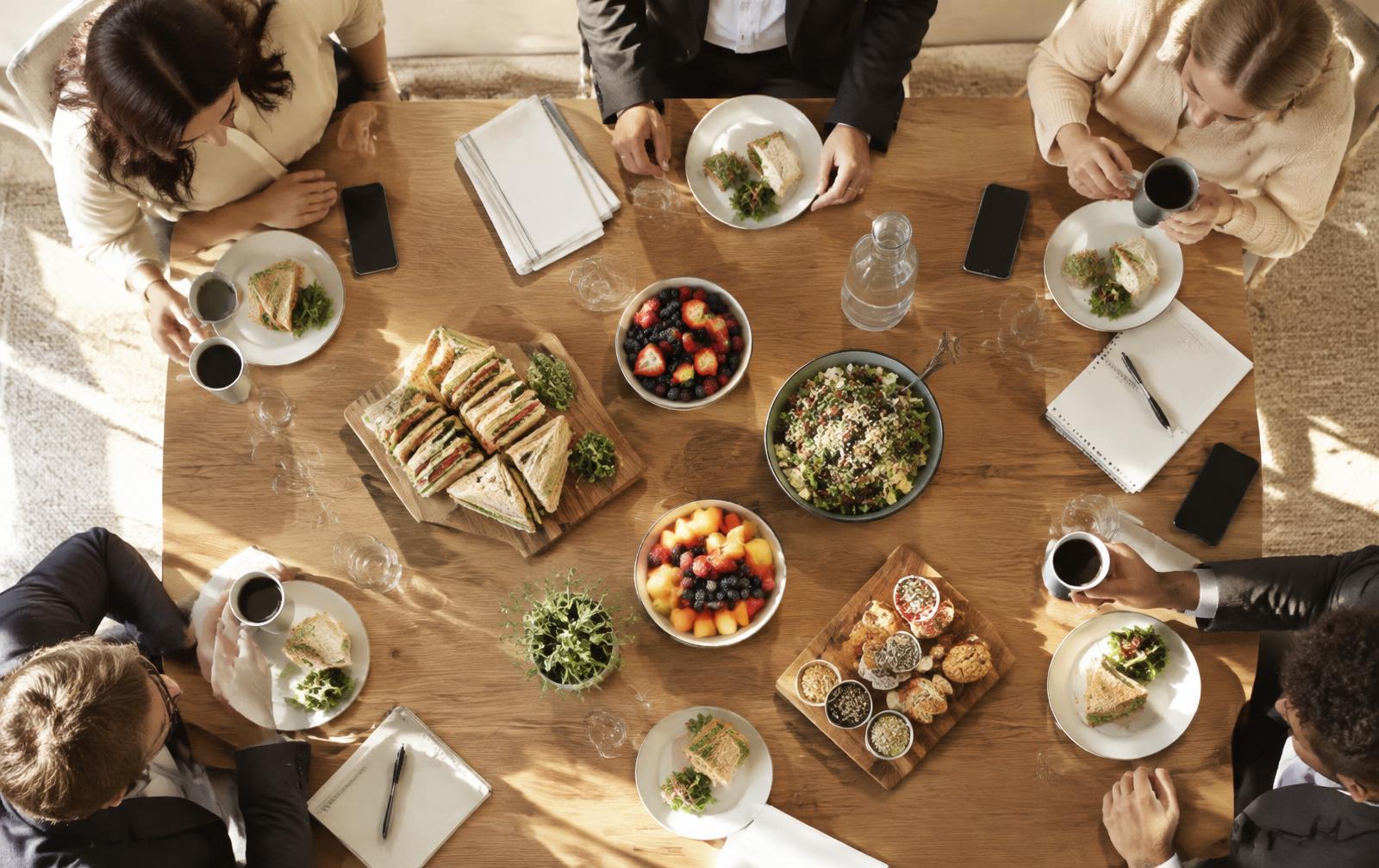 Vergadertafel met broodjes, fruit en koffie